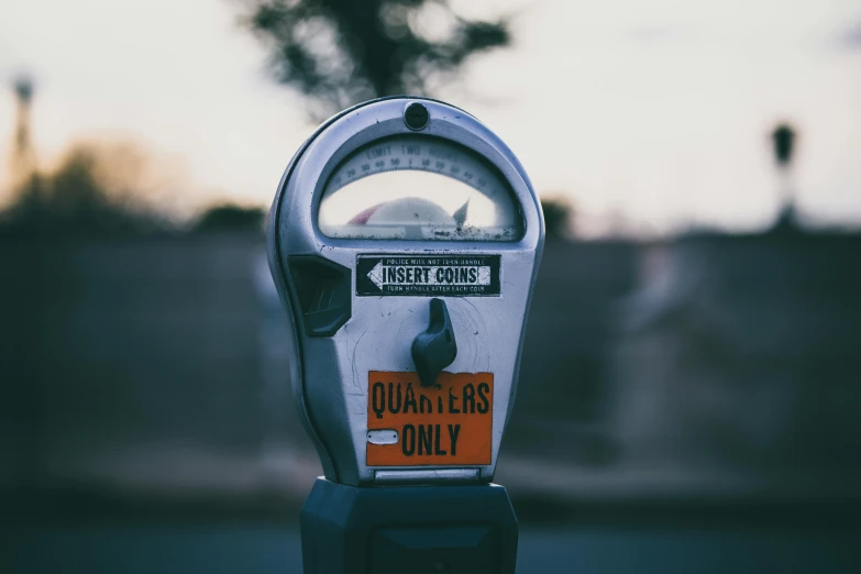 an old, dirty parking meter on the side of the street