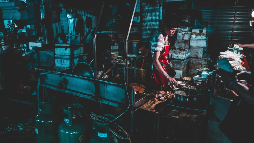 some people are standing and preparing food in a kitchen