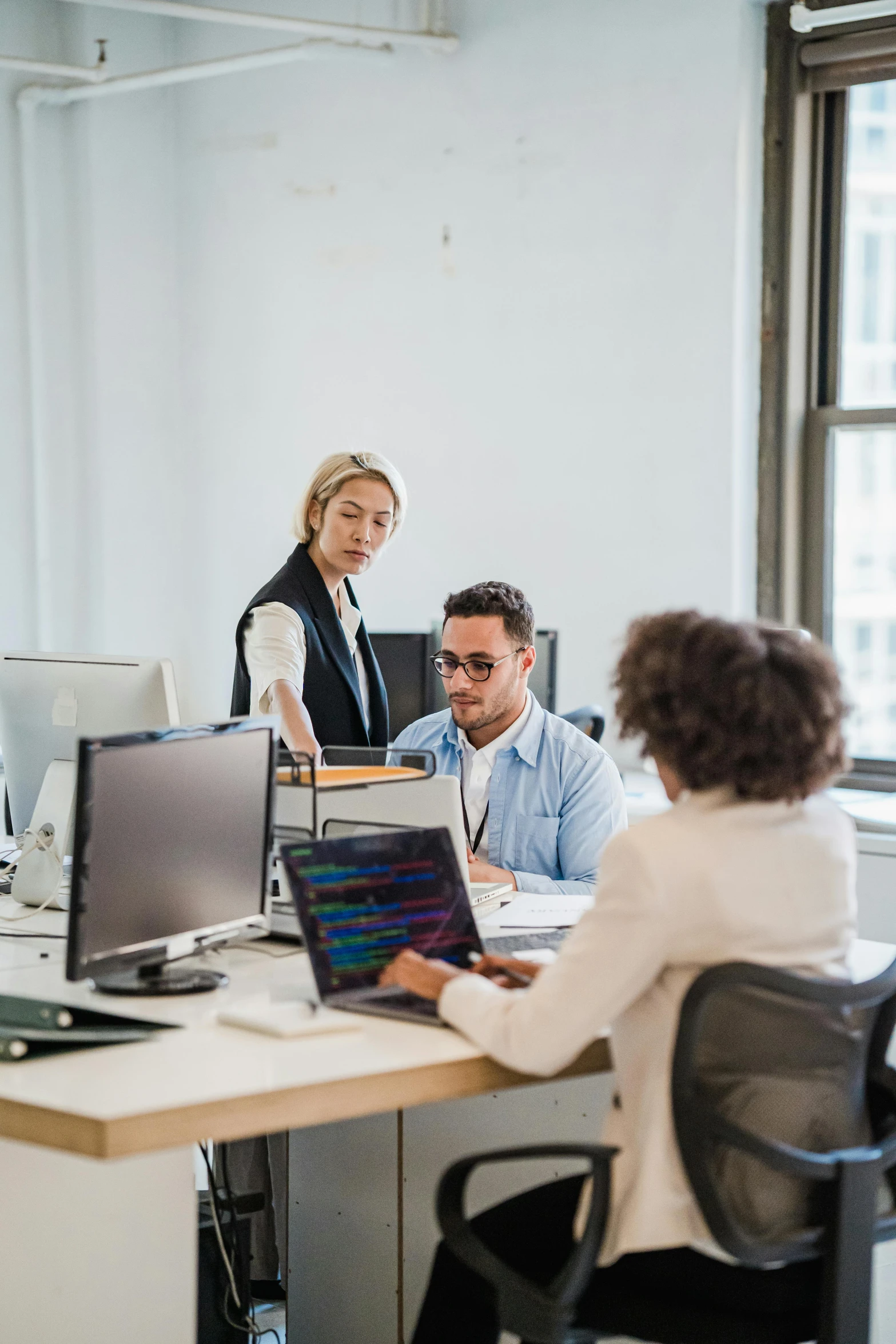 a group of people working around a desk