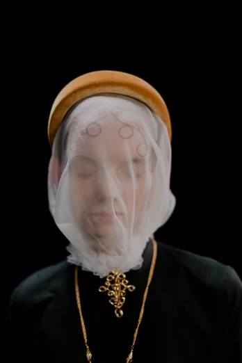 a woman wearing a white veil and a gold chain