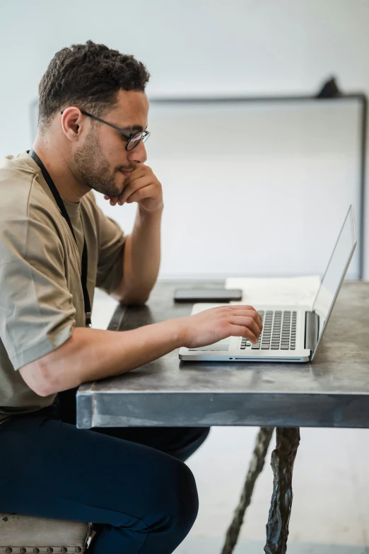 a man working on a laptop sitting at a table