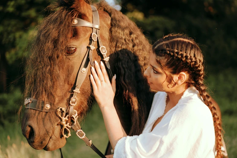 a girl petting the head of a horse