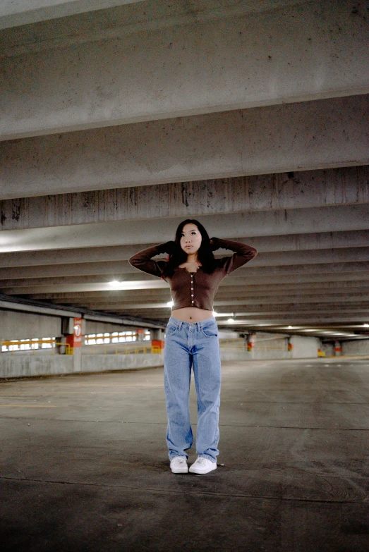 a woman with an open shirt and jeans is standing in a building