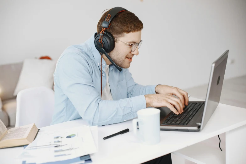 a man with headphones is using a laptop