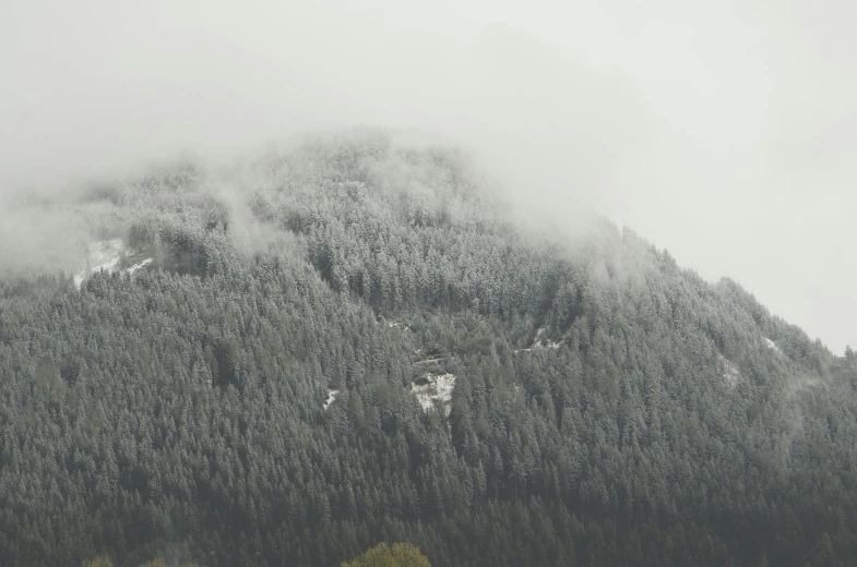 tall snow covered mountainside, with a low cloud