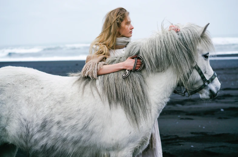 woman with long ids and ided hair sitting on top of a white horse