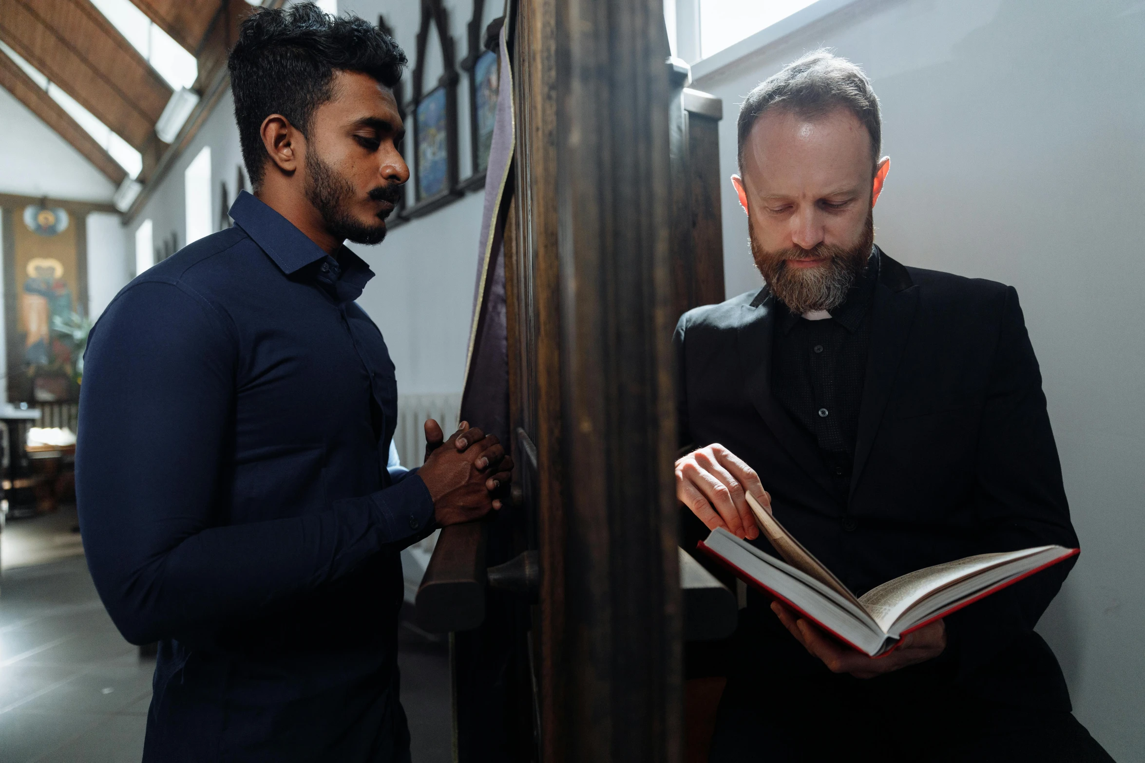 two people in church reading a book with each other