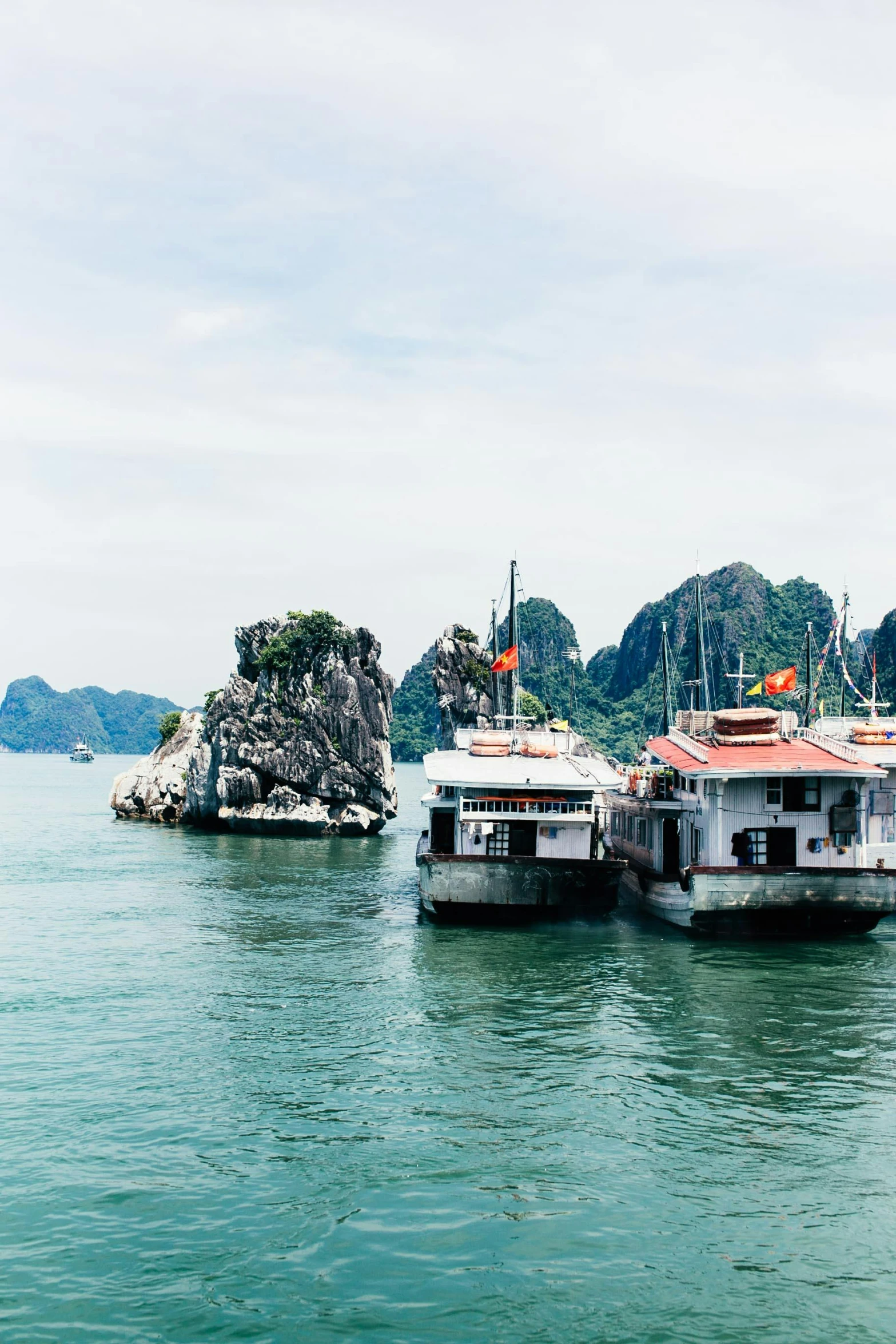 a couple of boats floating next to each other near mountains