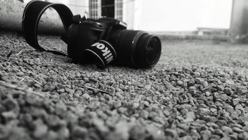 a camera is laying on the ground with its strap open