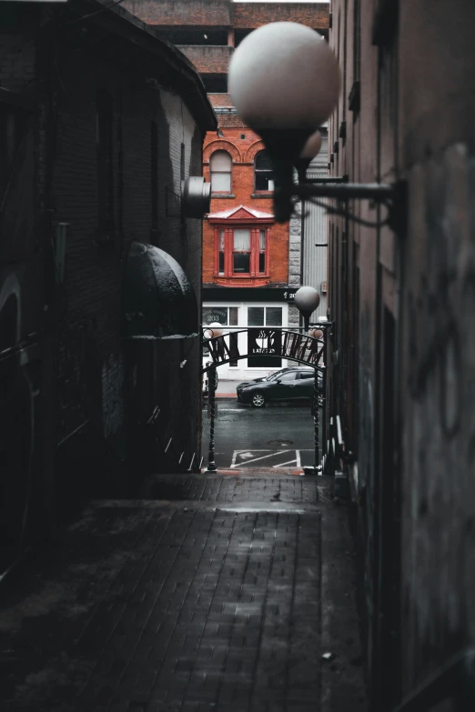 an alley with a red building and some bike racks