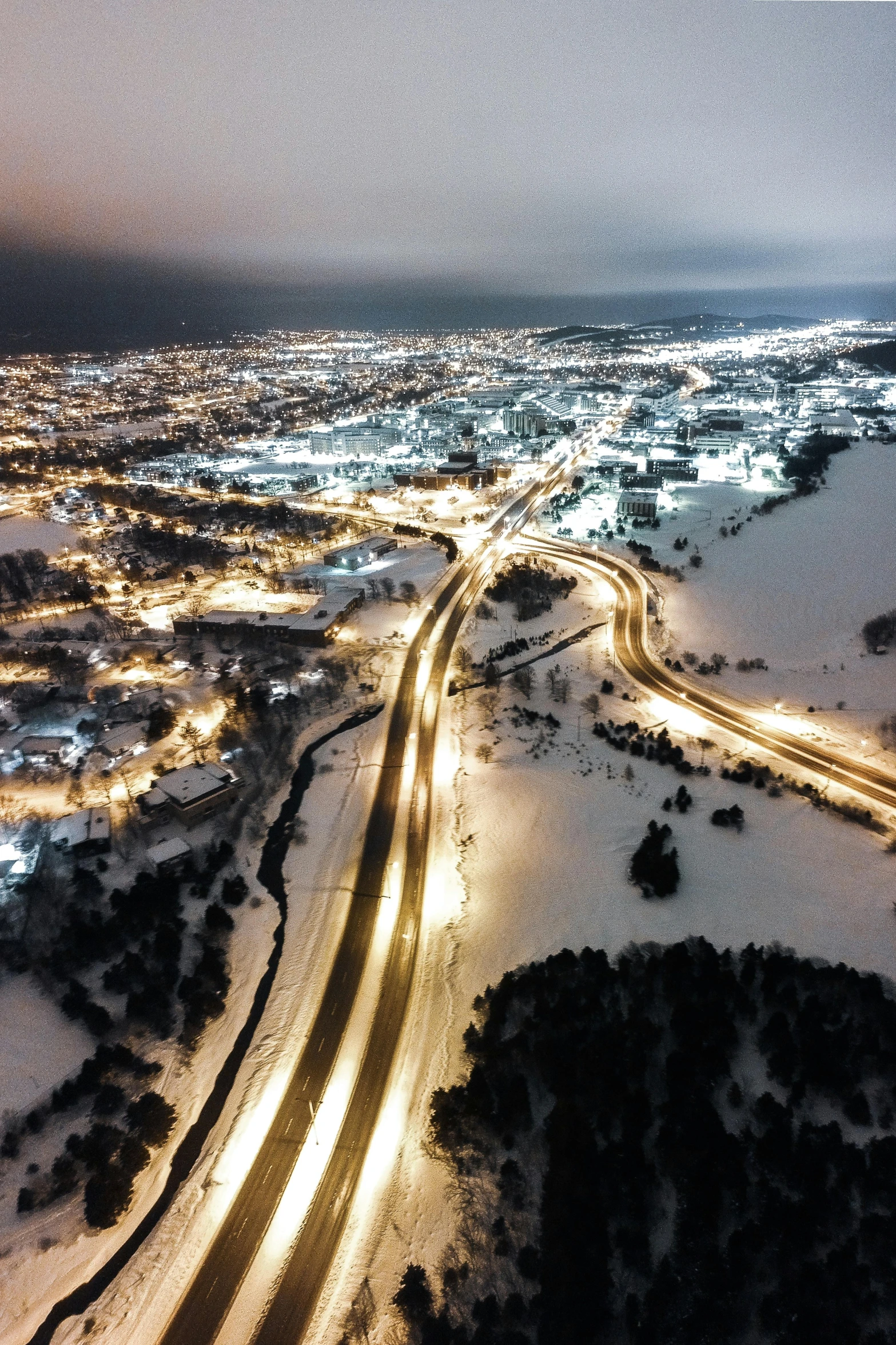 a nighttime view of traffic on a snowy road