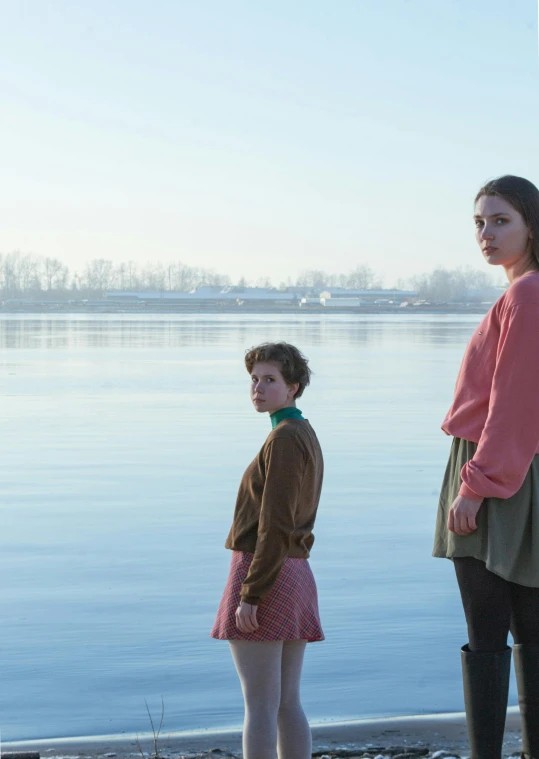 two people standing near a body of water