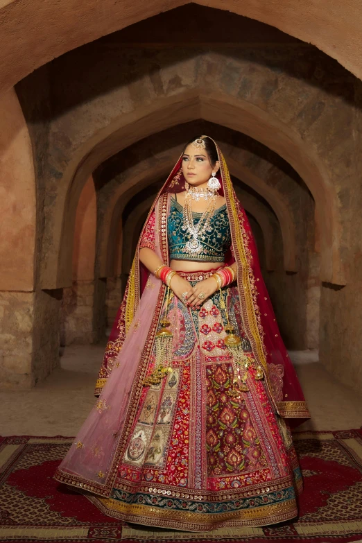 a woman in a traditional indian wedding outfit standing in a room