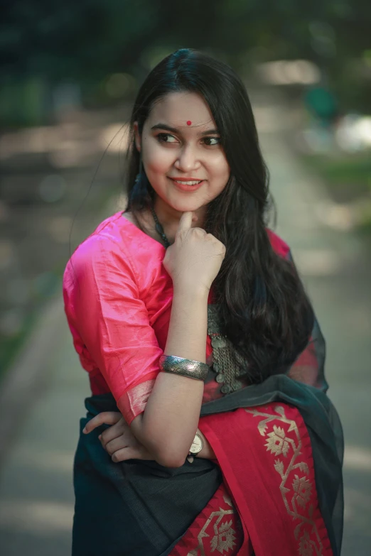 a young woman wearing a red and blue saree poses for a picture