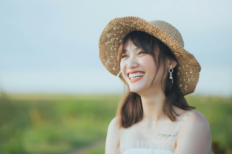 a woman wearing a straw hat smiling