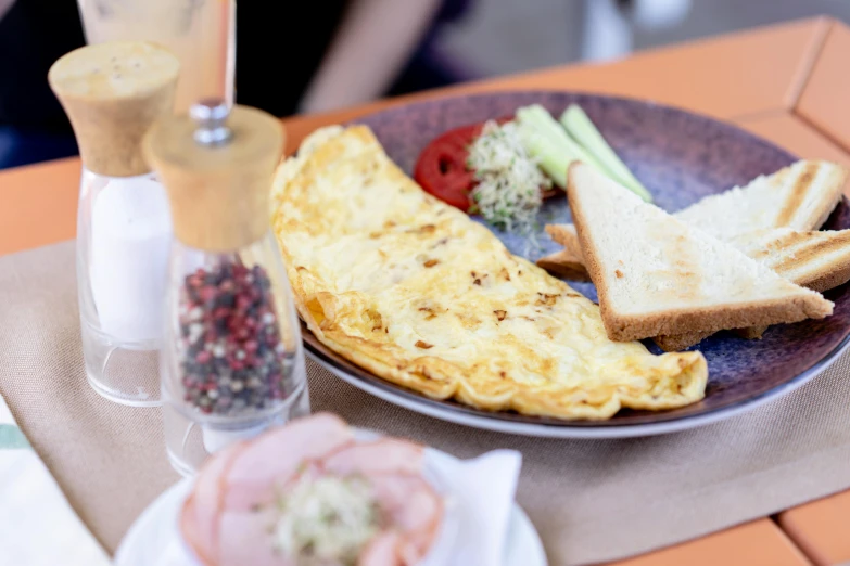 the ham, bread and vegetables are on a purple plate