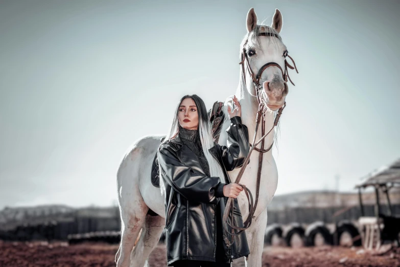 an indian girl poses with a horse on a farm