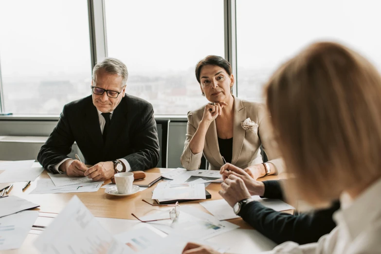 a group of business people sitting at a table working