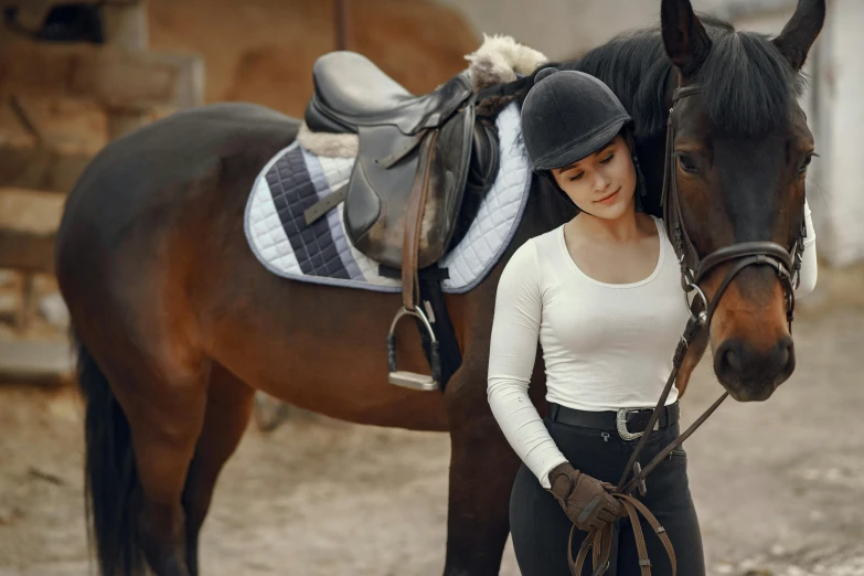 a woman standing next to a brown horse