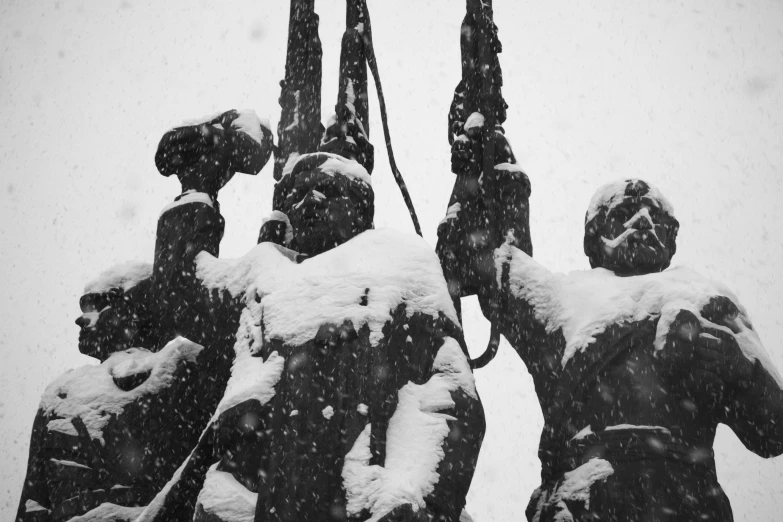 four statues with snow all around them