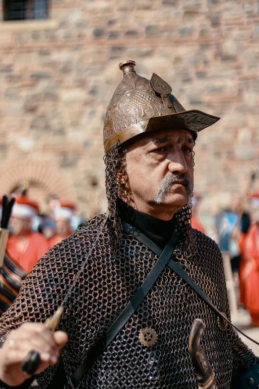 a man in armor holding soing up to his left shoulder