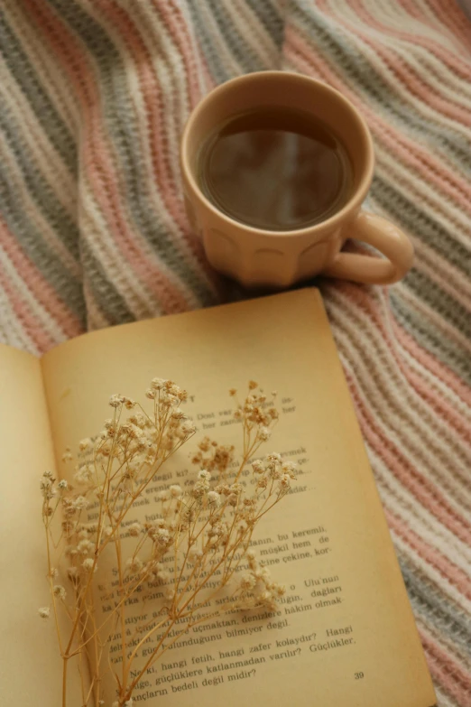 an open book is shown next to a cup of coffee