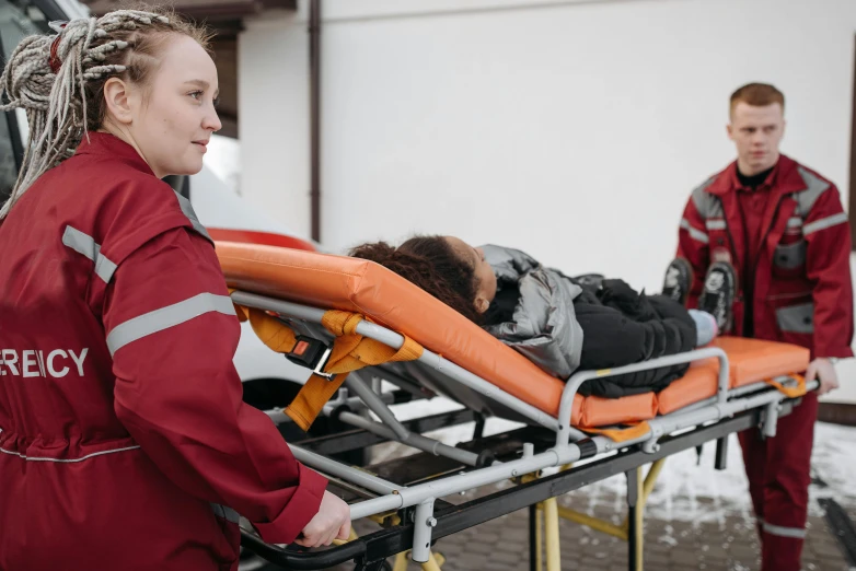 two people standing next to an ambulance cart