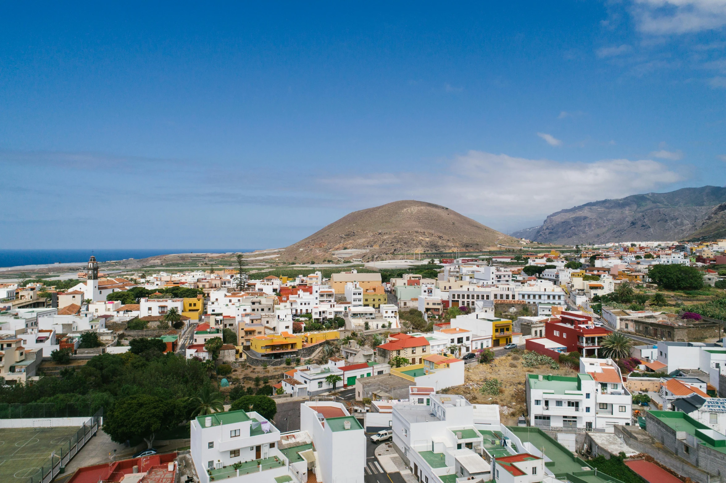 a city with houses and mountains in the background