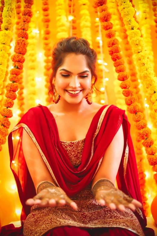 a woman sitting on the ground surrounded by garland