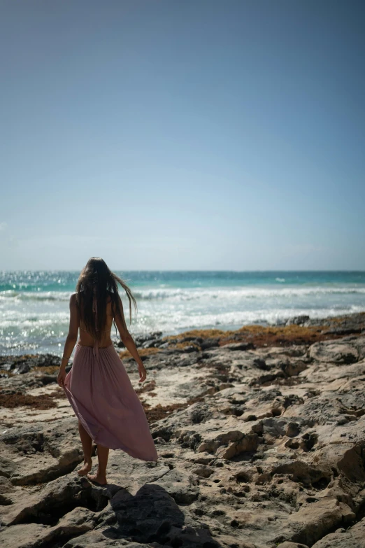 a  in a pink dress on the beach