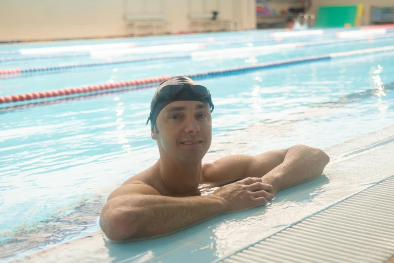 a young man is sitting in the water with his arms folded out