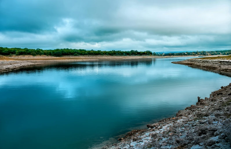 water with some grass near by on a cloudy day