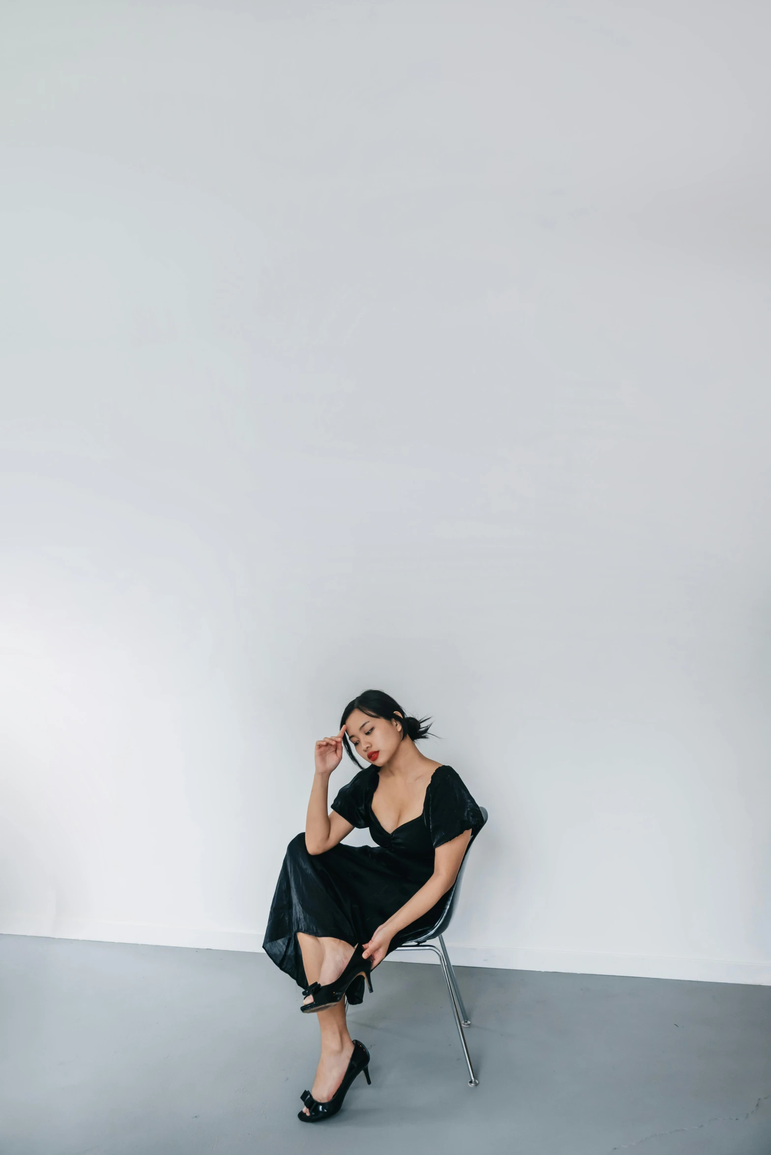 a woman sitting in a chair wearing high heels