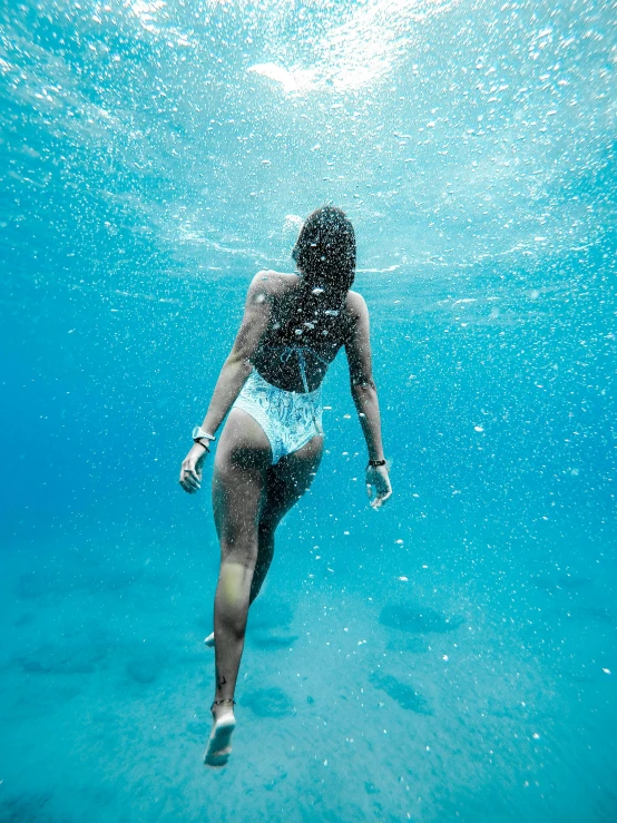 a woman in a bikini diving into the ocean