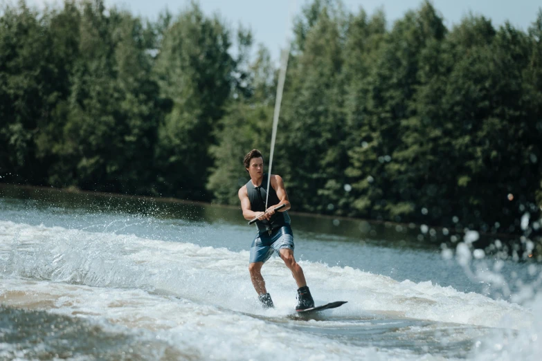 a man is riding water skis and holding a pole