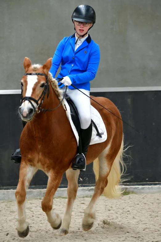 a person riding a brown horse near a building