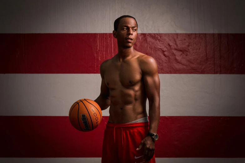a male basketball player in a studio with the american flag
