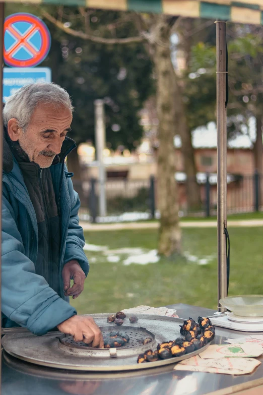 a man grilling outside with no food on his plate