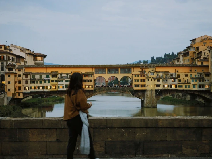 a woman looking over a bridge that is over water