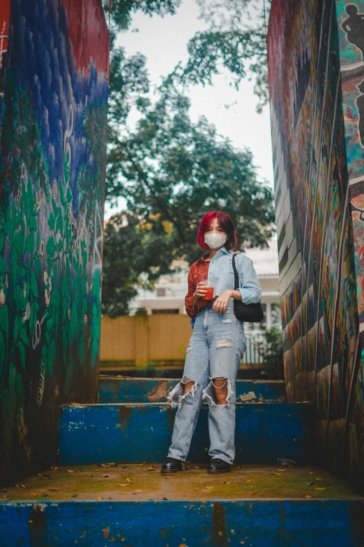 a woman posing on steps in front of graffiti covered walls