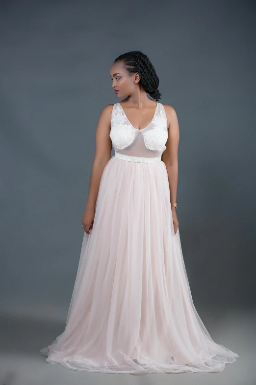 an african woman poses in a pink gown