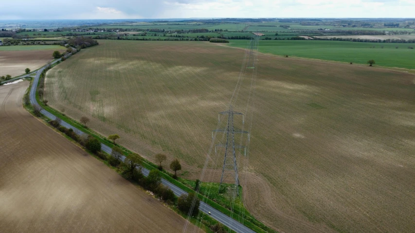 an aerial view of a road through a farm land