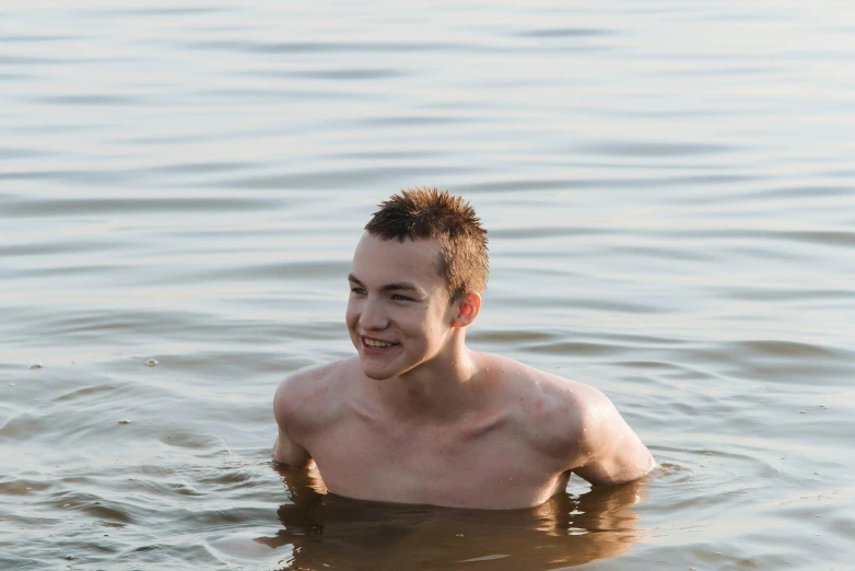 a guy in the water smiles in the day time