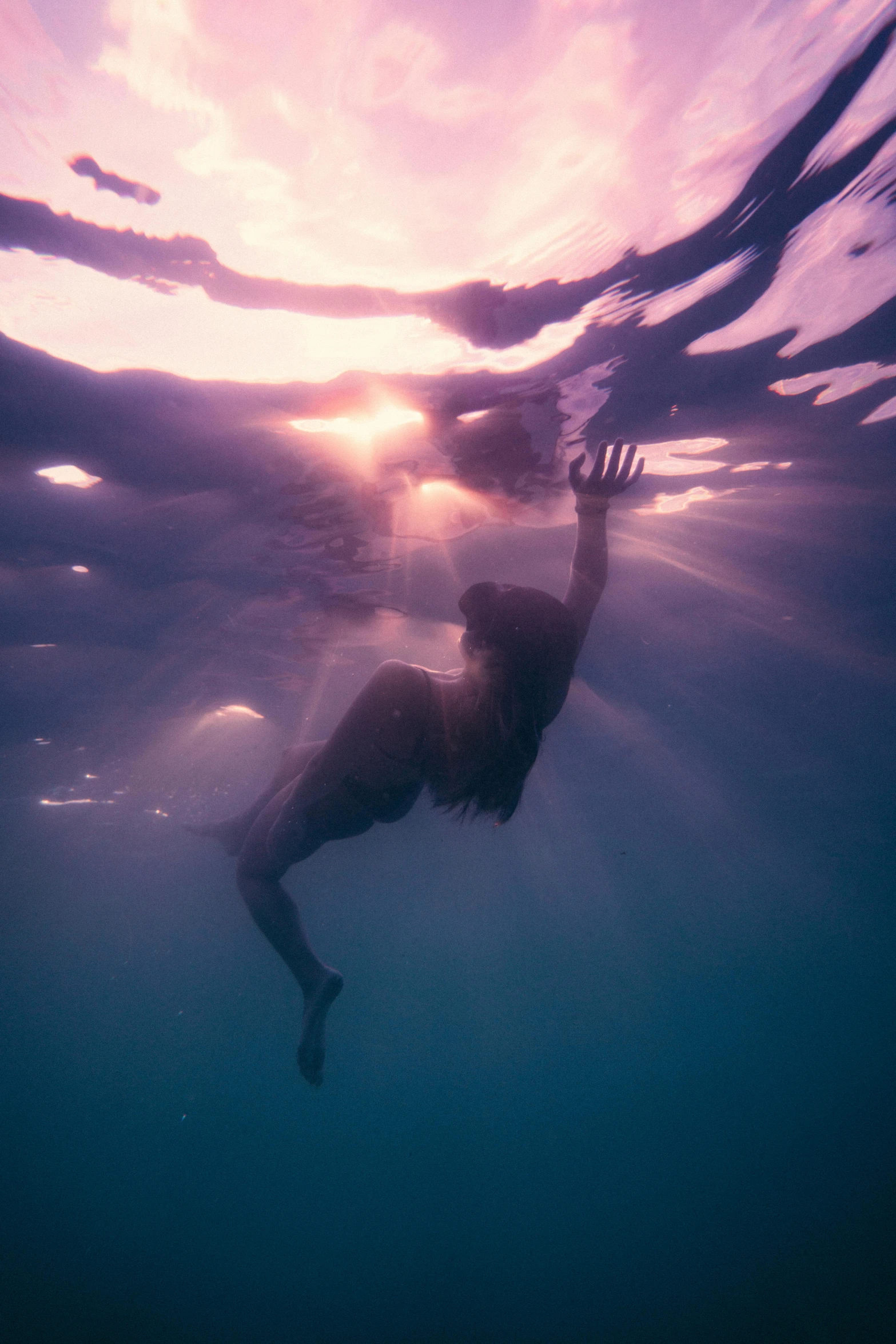 a man swimming in the ocean while holding his arm up