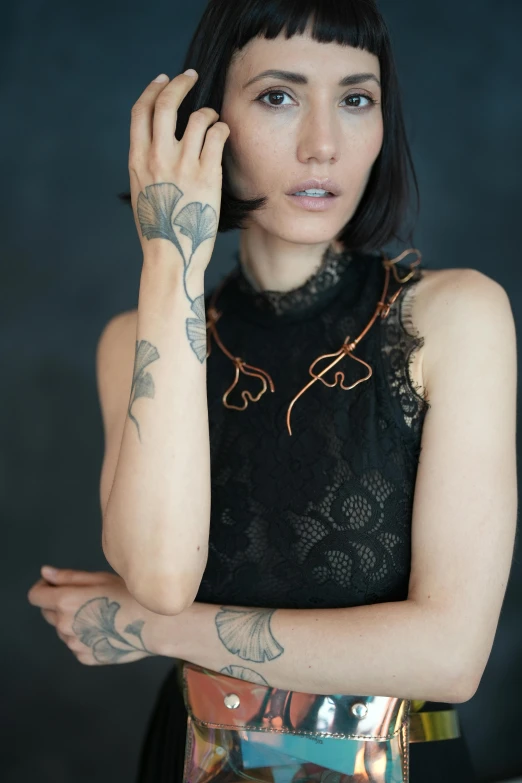 a woman that has a tattooed arm holding a cell phone