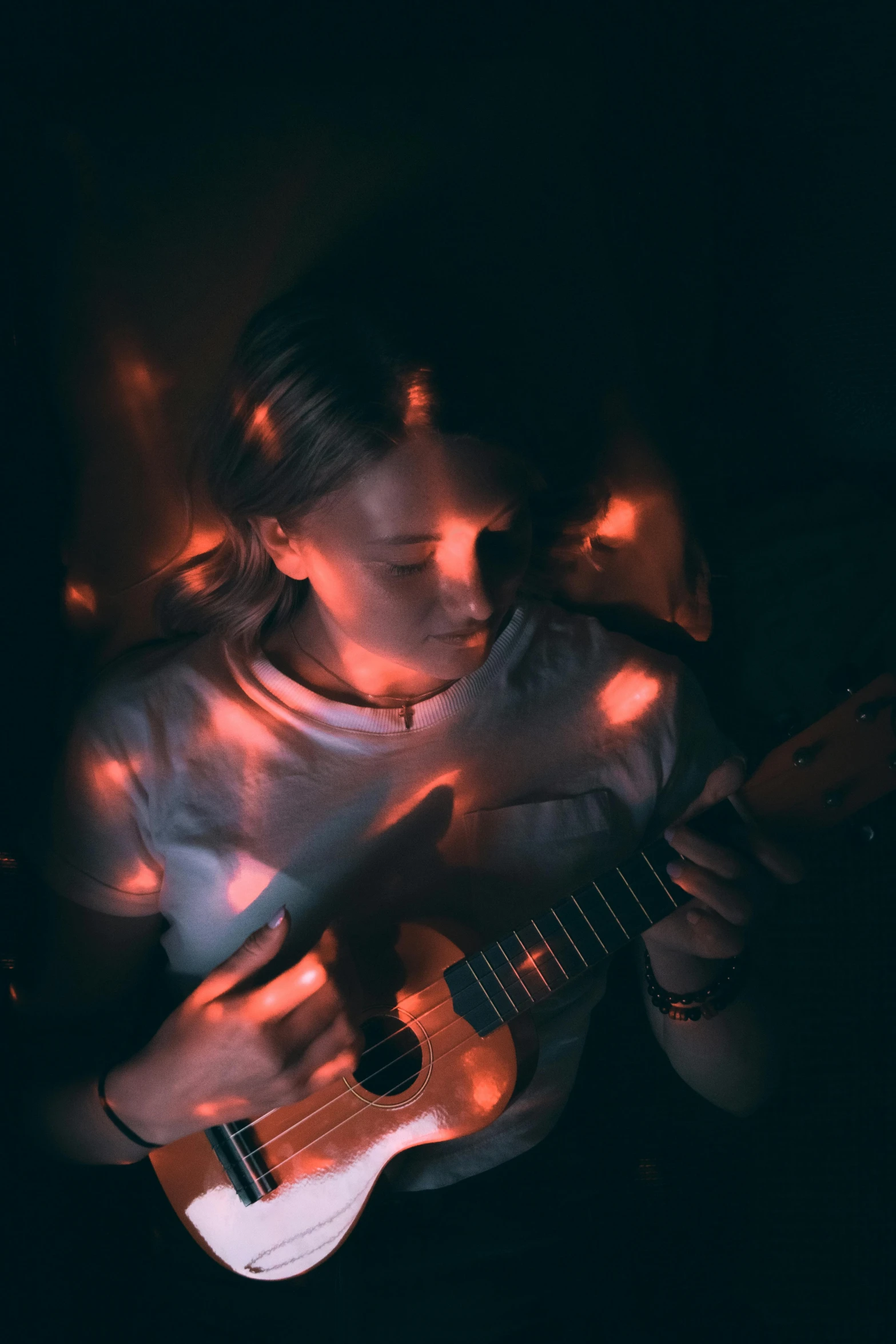 a girl is playing guitar on the ground