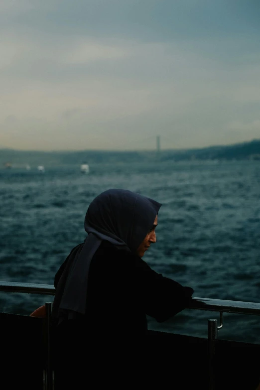 a woman is looking at the water from a ferry