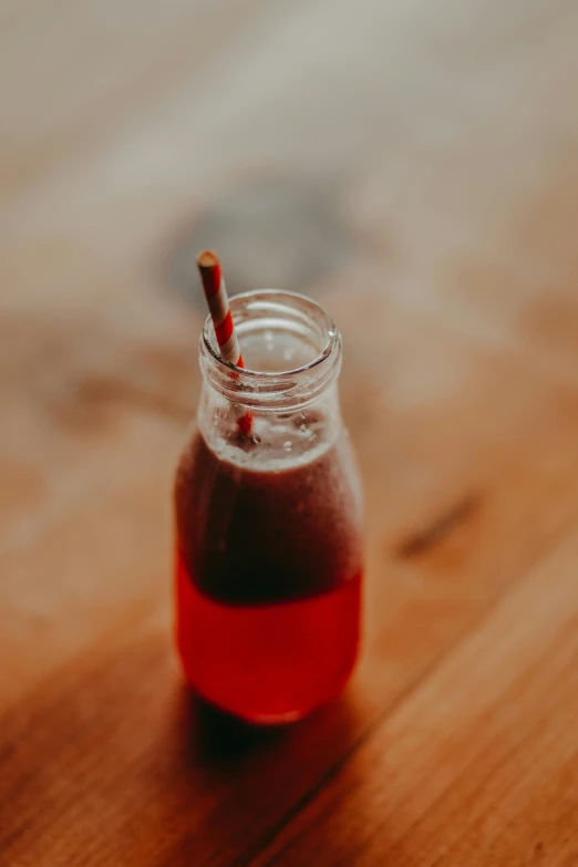 a red liquid is in a small mason jar