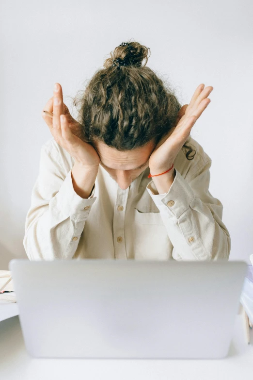 a woman with her hands together, holding the laptop