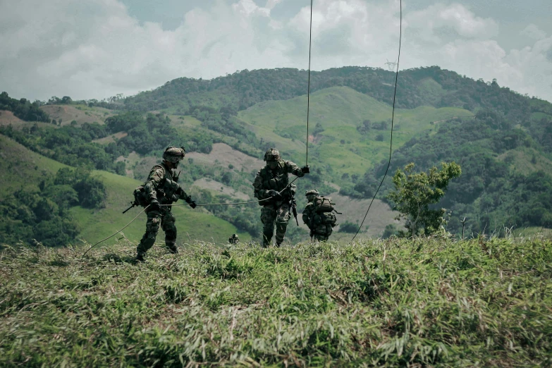 some military personnel are walking on a hill